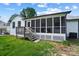 Enclosed porch with steps leading to the backyard and well-maintained landscaping at 5428 Barnsdale Ln, Mint Hill, NC 28227