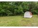 View of the backyard featuring a storage shed and bordered by lush trees at 565 Vine Arden Dr, Salisbury, NC 28146