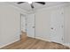 A simple bedroom with wood-look floors, a ceiling fan, and a view into the hallway at 565 Vine Arden Dr, Salisbury, NC 28146