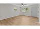 Bright bedroom with light wood floors, two windows, and a gray painted door at 565 Vine Arden Dr, Salisbury, NC 28146