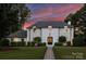Stunning two-story white brick home with manicured lawn and beautiful trees at 5806 Bentway Dr, Charlotte, NC 28226