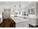 Bright, white kitchen boasts a large marble island, stainless steel appliances, and pendant lighting at 5806 Bentway Dr, Charlotte, NC 28226