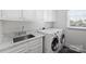 Laundry room with white cabinets, marble counters, utility sink and washer and dryer at 5806 Bentway Dr, Charlotte, NC 28226