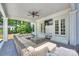 A covered patio with a large wicker sectional sofa, ceiling fan, and an outdoor television at 5806 Bentway Dr, Charlotte, NC 28226