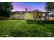 Backyard view, twilight setting with well-maintained lawn at 6100 Ashcrest Dr, Charlotte, NC 28217