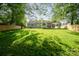 Spacious backyard with lush green lawn, privacy fence, and covered patio at 6100 Ashcrest Dr, Charlotte, NC 28217