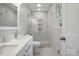 Bright bathroom featuring a glass shower door, marble accents, and a modern vanity at 6100 Ashcrest Dr, Charlotte, NC 28217