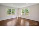Bright bedroom with hardwood floors and large windows offering natural light and views of the landscaped backyard at 6100 Ashcrest Dr, Charlotte, NC 28217