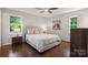 Cozy bedroom with hardwood floors, neutral decor, and two windows offering natural light at 6100 Ashcrest Dr, Charlotte, NC 28217