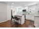 Stylish kitchen with white cabinetry, marble countertops, stainless steel appliances, and a central island with bar seating at 6100 Ashcrest Dr, Charlotte, NC 28217
