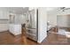 Modern kitchen featuring stainless steel refrigerator and island, opening to a comfortable living space with neutral tones at 6100 Ashcrest Dr, Charlotte, NC 28217