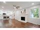 Open-concept living area with white brick fireplace and modern kitchen views at 6100 Ashcrest Dr, Charlotte, NC 28217