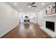 Open-concept living room with white brick fireplace and hardwood floors, leading into a modern kitchen with an island at 6100 Ashcrest Dr, Charlotte, NC 28217