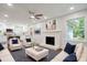 Bright living room featuring a white brick fireplace, modern artwork, and comfortable seating with blue accents at 6100 Ashcrest Dr, Charlotte, NC 28217