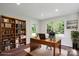 Dedicated home office with wooden desk, shelving and backyard view at 6100 Ashcrest Dr, Charlotte, NC 28217