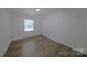 Bedroom features hardwood floors, a bright window, and neutral paint for a serene atmosphere at 6124 Coach Hill Ln, Charlotte, NC 28212