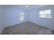 Bedroom with light hardwood floors and two bright windows, freshly painted at 6124 Coach Hill Ln, Charlotte, NC 28212