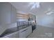 Modern kitchen with stainless steel appliances, gray cabinets, and light hardwood floors, ready for cooking at 6124 Coach Hill Ln, Charlotte, NC 28212