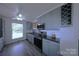 Updated kitchen featuring stainless steel appliances, gray cabinets, open shelves, and a modern backsplash at 6124 Coach Hill Ln, Charlotte, NC 28212