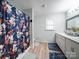 Bathroom featuring double vanity, tub/shower with a floral curtain and neutral walls at 6604 Plyler Mill Rd, Monroe, NC 28112