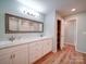 Bright bathroom featuring double sinks, wood floor, and an attached linen closet at 6604 Plyler Mill Rd, Monroe, NC 28112