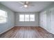 This bedroom features a ceiling fan, a large window and beautiful laminate flooring at 6604 Plyler Mill Rd, Monroe, NC 28112
