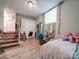 Bright bedroom with wood floors, window with vines, closet and stairs to another level at 6604 Plyler Mill Rd, Monroe, NC 28112