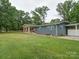 Well-maintained single-story home with a stone porch, side carport, and lush green lawn at 6604 Plyler Mill Rd, Monroe, NC 28112