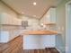 Bright kitchen features white cabinets, updated appliances, butcher block island, and hardwood flooring at 6604 Plyler Mill Rd, Monroe, NC 28112