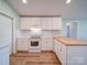 Bright kitchen features white cabinets, updated appliances, butcher block island, and hardwood flooring at 6604 Plyler Mill Rd, Monroe, NC 28112