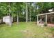 Backyard featuring a covered patio with outdoor kitchen, with lush lawn and mature trees at 6640 Autumn Gate Ln, Charlotte, NC 28216