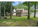 A backyard surrounded by mature trees featuring a covered patio with an outdoor kitchen at 6640 Autumn Gate Ln, Charlotte, NC 28216