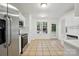 Bright kitchen with tile flooring, white cabinets, stainless steel appliances, and a window overlooking backyard at 6640 Autumn Gate Ln, Charlotte, NC 28216