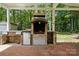 An outdoor kitchen with a built-in grill and prep area under a covered structure at 6640 Autumn Gate Ln, Charlotte, NC 28216