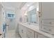 Bright bathroom featuring white cabinets, a large mirror, and marble floors at 6664 Lake Shore Dr, Hickory, NC 28601