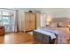 Cozy bedroom with hardwood floors, large windows, and a decorative wood accent cabinet at 6664 Lake Shore Dr, Hickory, NC 28601
