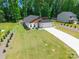 Aerial view of a home with a large front yard, modern design, and long driveway at 7728 Shalom Dr, Charlotte, NC 28216