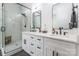 This bathroom showcases a glass shower enclosure and a white double vanity with black hardware at 7728 Shalom Dr, Charlotte, NC 28216