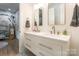 Bright bathroom boasting double sinks, white cabinets with black hardware, and a full-sized mirror at 7728 Shalom Dr, Charlotte, NC 28216