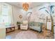 Charming Bedroom with whimsical wallpaper, a cozy armchair, and a decorative woven chandelier at 7728 Shalom Dr, Charlotte, NC 28216
