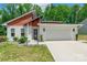 Modern home with white stucco, wood accents, black trim, large garage and well maintained yard at 7728 Shalom Dr, Charlotte, NC 28216