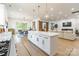 An open-concept kitchen with an expansive island, perfect for entertaining, and views into the dining and living areas at 7728 Shalom Dr, Charlotte, NC 28216