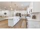 Modern kitchen featuring a large island, white cabinets, stainless appliances, and stylish pendant lights at 7728 Shalom Dr, Charlotte, NC 28216