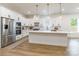 Modern kitchen featuring white cabinets, stainless steel appliances, large island, and pendant lighting at 7728 Shalom Dr, Charlotte, NC 28216