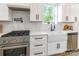 This kitchen features white subway tiles, white cabinets, stainless steel appliances, and a farmhouse sink at 7728 Shalom Dr, Charlotte, NC 28216