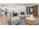 Living room with an open layout showcasing a modern kitchen, dining area, and a comfortable sectional sofa at 7728 Shalom Dr, Charlotte, NC 28216