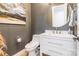 Chic powder room with modern vanity, round mirror, and elegant decor, perfect for guests at 7728 Shalom Dr, Charlotte, NC 28216
