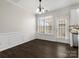 Bright dining area featuring dark wood floors, decorative molding, and a modern chandelier at 8037 Lynwood Sq, Waxhaw, NC 28173