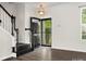 Welcoming entryway with dark wood floors, staircase, and modern lighting fixture at 8037 Lynwood Sq, Waxhaw, NC 28173