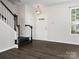 Bright entryway with dark wood floors, staircase, and window providing natural light at 8037 Lynwood Sq, Waxhaw, NC 28173
